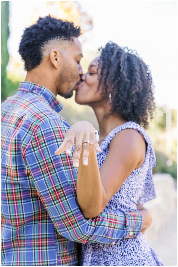 Fiancee kissing her fiance and showing off her ring