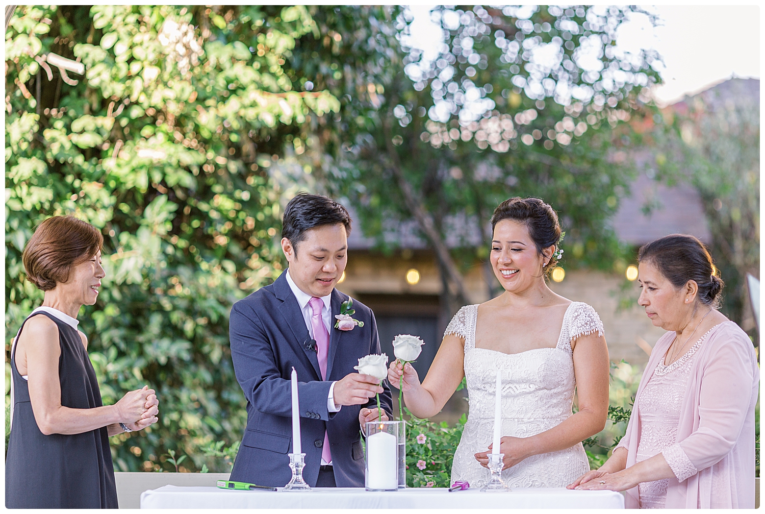 Bride and groom adding flowers to the family unity vase