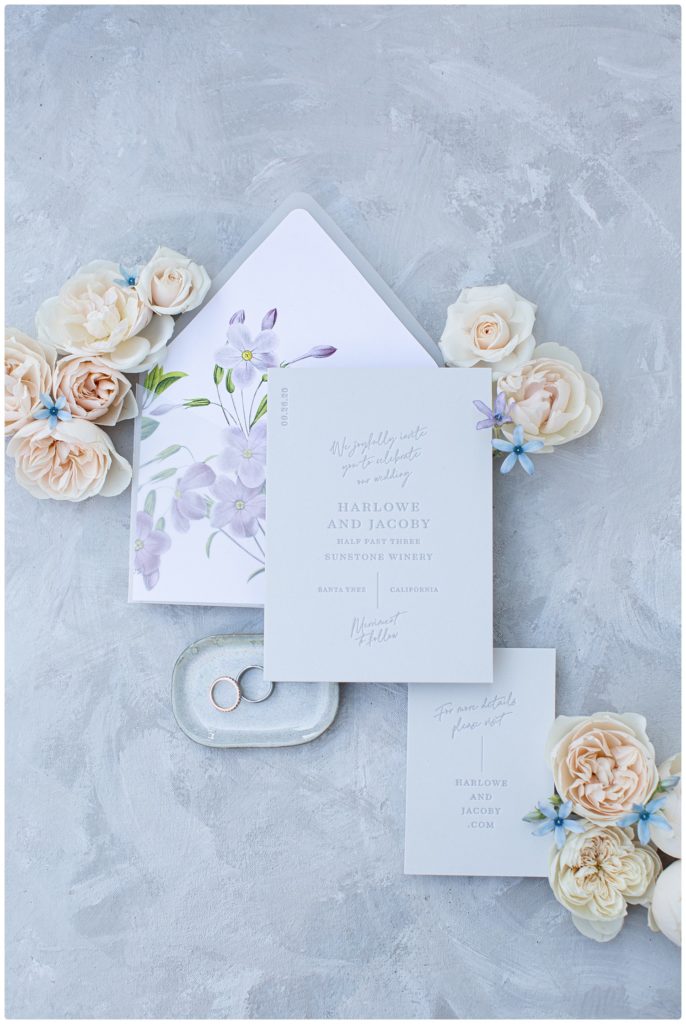 invitation suite with flowers and wedding rings