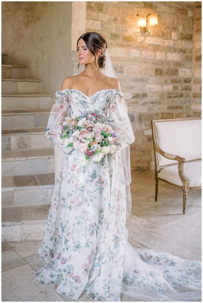 bride in floral wedding gown with bouquet - sunstone winery