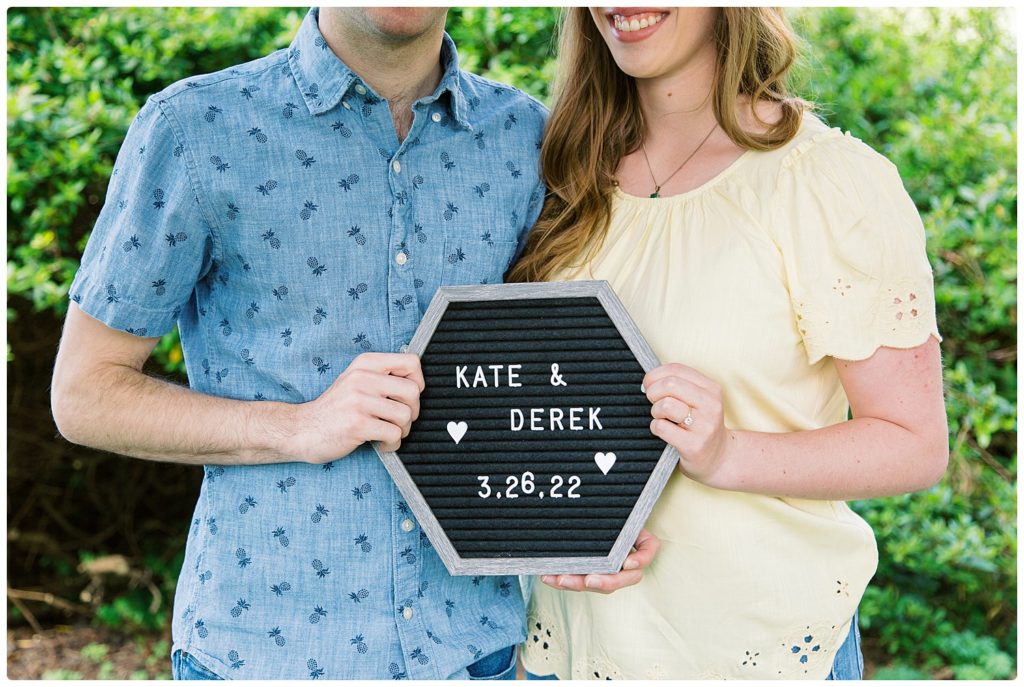 engaged couple holding engagement date sign to complement their engagement story