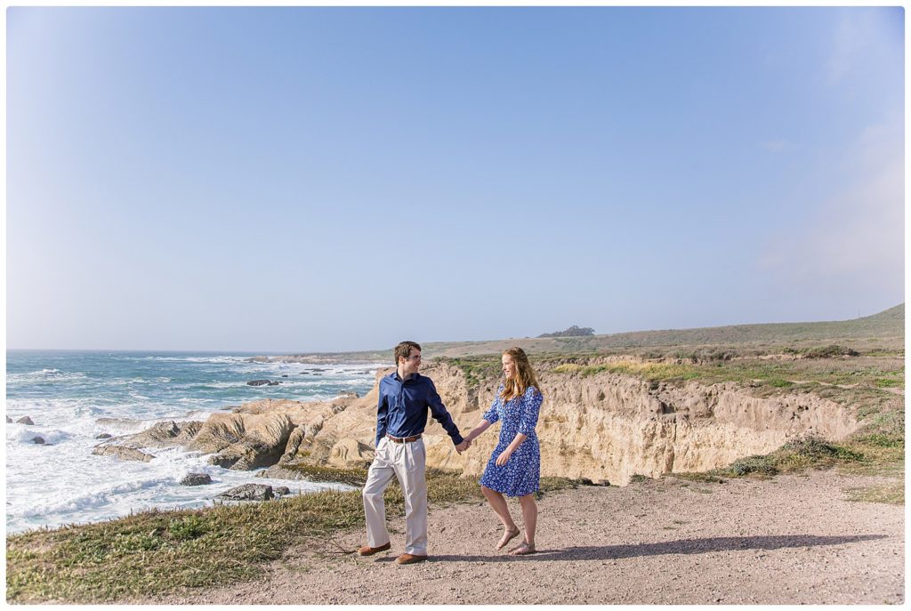 engaged couple walking along the ocean cliffs at montana del oro