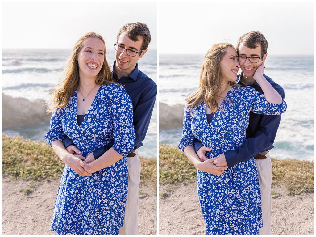smiling engaged couple with male hugging female from behind on ocean cliffs