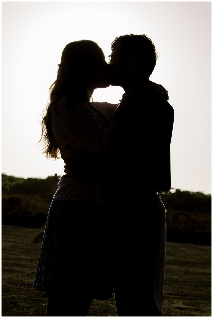 silouette of engaged couple kissing