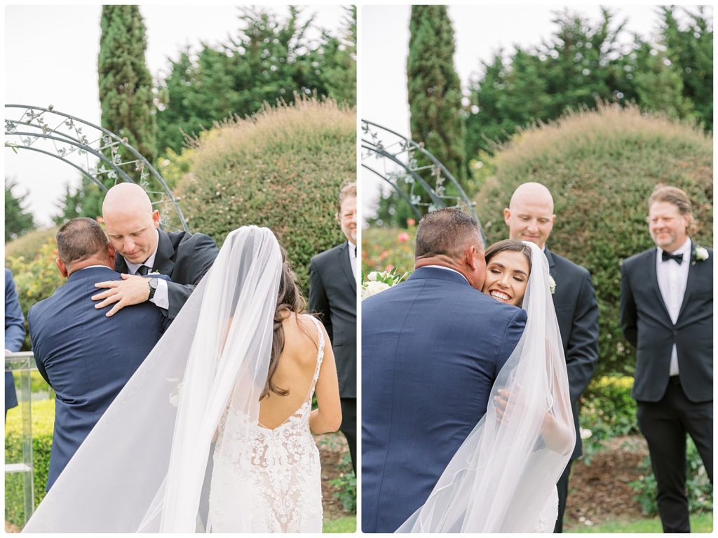 father of the bride being hugged by bride and groom