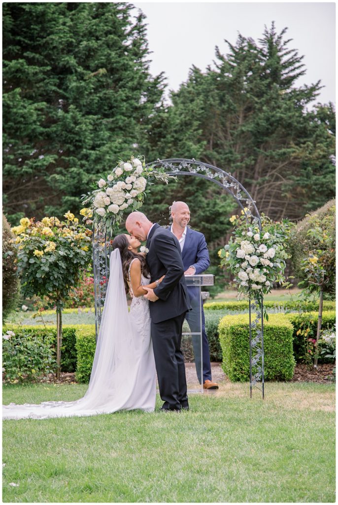bride and groom kissing at the alter at their wedding in the garden at Heritage Estates