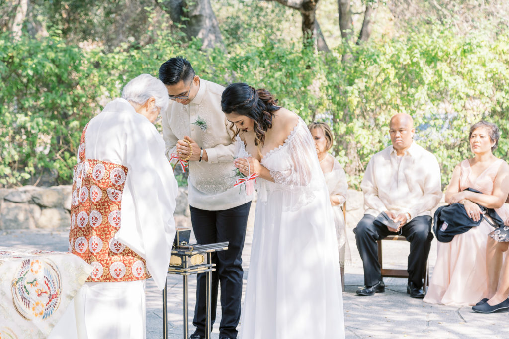 Wedding couple bowing to the officiant