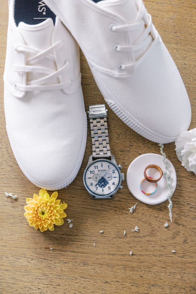 groom boho wedding beach details, his shoes, watch, rings and flowers to decorate the area