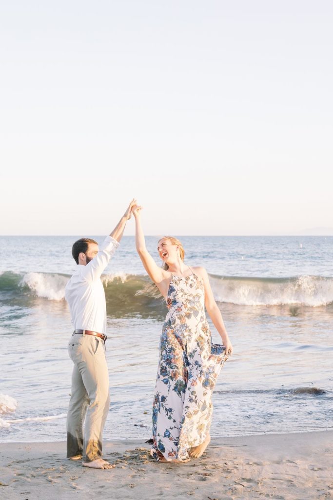 Engaged couple dancing on beach