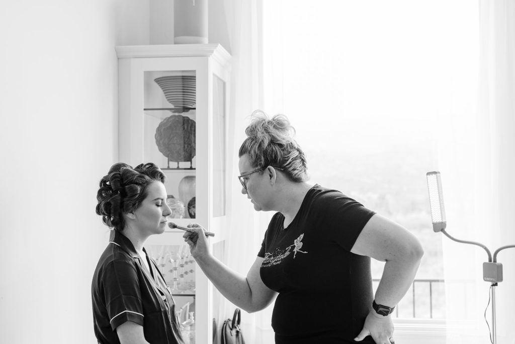 Bride getting ready for her wedding with make up artist